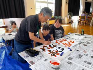 書道を先生から教わっている様子