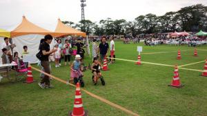 ふるさとまつりでキックバイクを体験する子どもたち