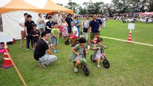 ふるさとまつりでキックバイクを体験する子どもたち